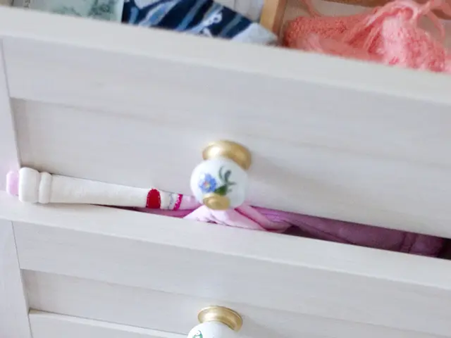 In this image we can see cupboard with drawers with clothes in it.