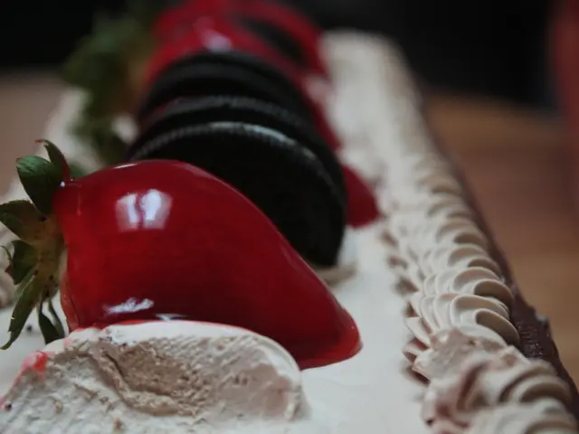 In this picture there is a cake in the center of the image, on which there are strawberries and...