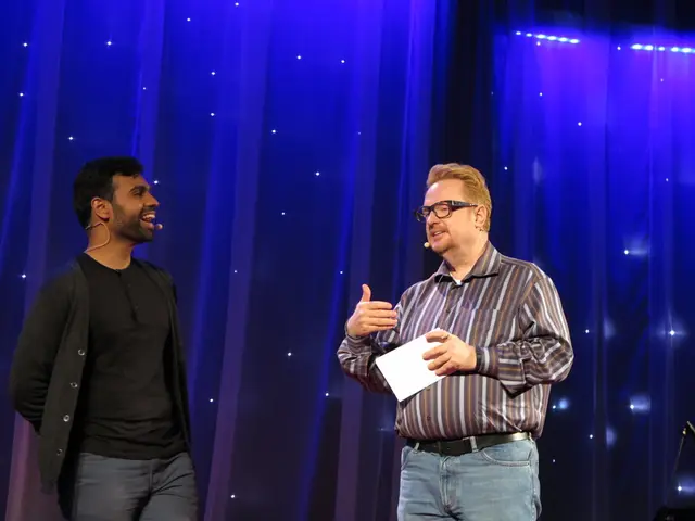 In the center of the picture there is a person holding a paper and talking into a mic. On the left...