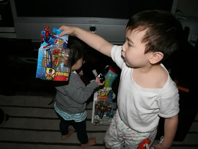 In this image we can see two kids who are wearing white and ash color dresses holding spider-man...