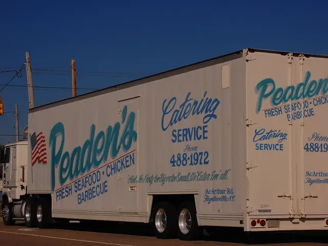 In the center of the image we can see a truck on the road. On the left there is a shed. In the...