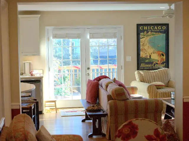 This picture is clicked inside the room. On the right side there are sofas. On the wall there is a...