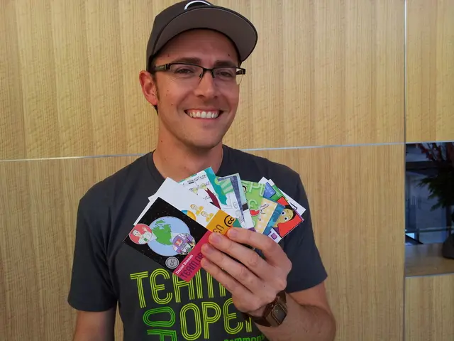 In this image there is a person with a smile on his face, holding some cards in his hand.