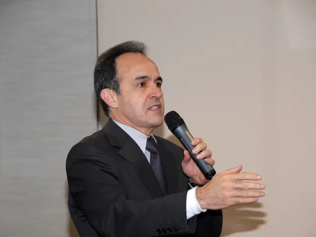 In the picture there is a man he is wearing black color coat he is holding mike in his left hand he...