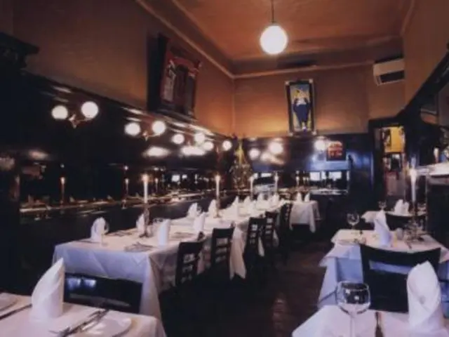 In this image there are glasses, candles with candles stands, napkins, plates and some other items...