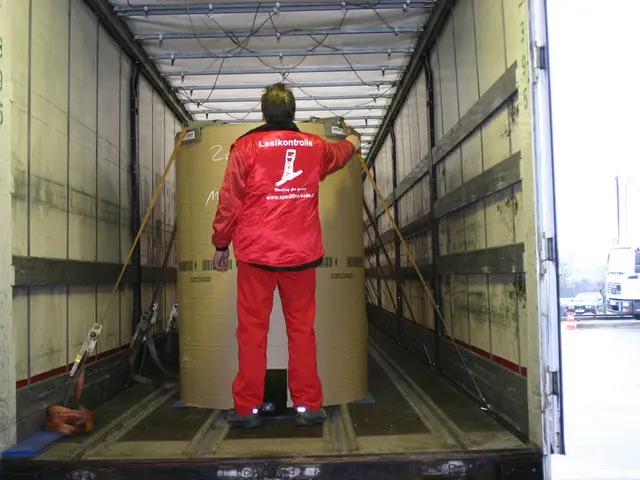 In this picture we can see a person holding a drum inside the truck, side we can see few vehicles...