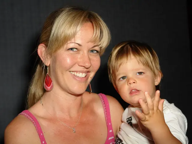 In this picture we can see a woman and a kid, and she is smiling.