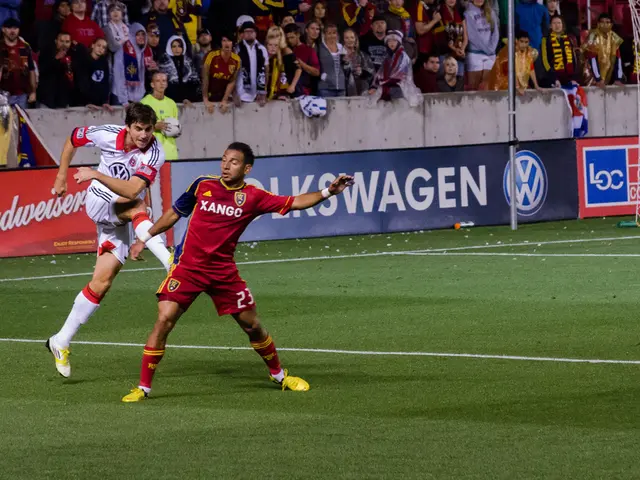 In this image in the center there are persons playing. In the background there is a person wearing...