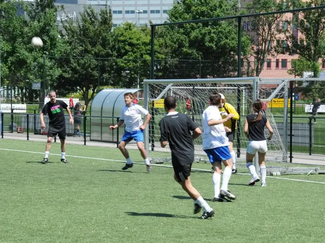 In this image, we can see persons wearing clothes and playing football. There is a fencing and...