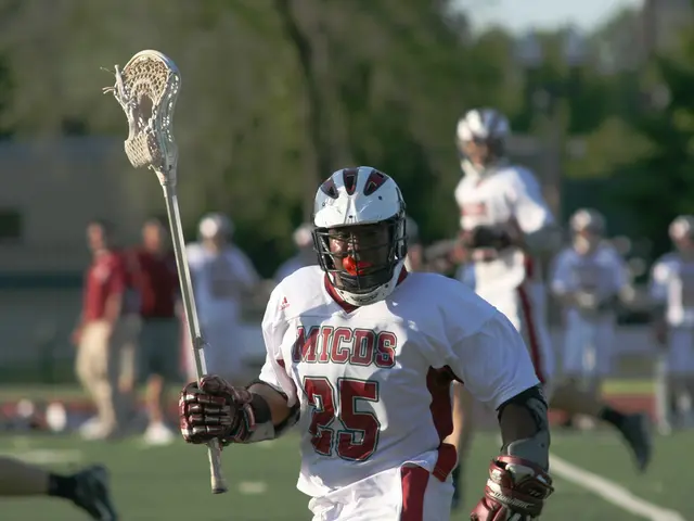 In this image there is a man in the middle who is holding the lacrosse stick. In the background...