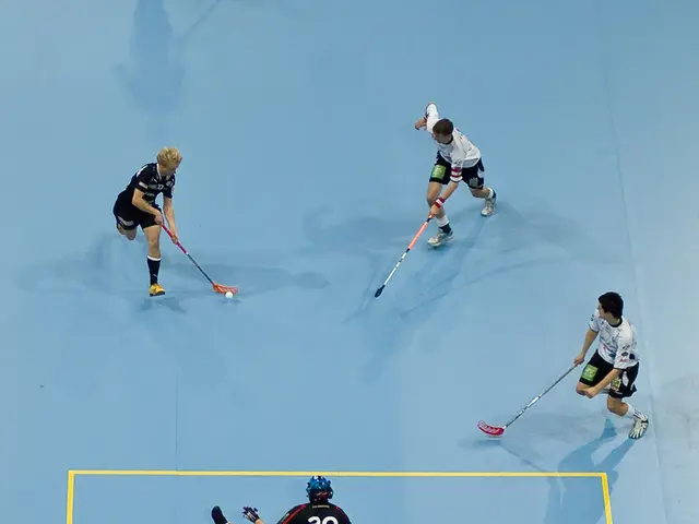 In this image there are few persons playing hockey. Three persons wearing sports dress are holding...