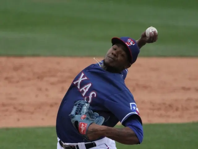 In this image there is a baseball player who is standing on the ground and throwing the ball.
