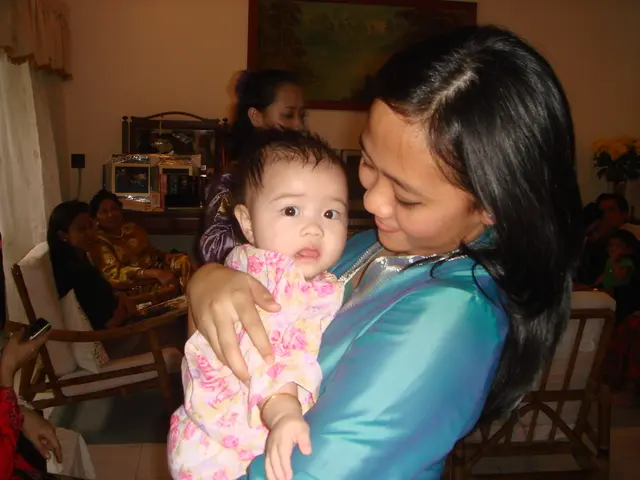 In this picture there are people, among them there is a woman standing and smiling and holding a...