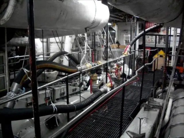 In this image I can see black color pipes, a fence and some other machines.