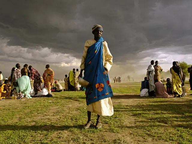 This picture describe about the women wearing blue color dress standing in the middle of the image...