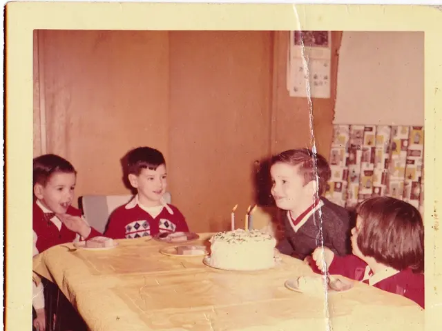 In this image I see a photo over here and I see 4 children and I see a table on which there is a...