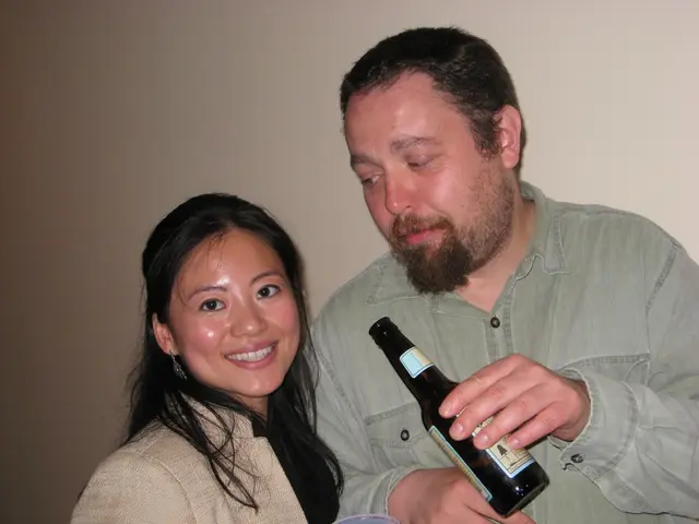 On the background there is a wall. We can see this man holding a bottle in his hand and staring at...