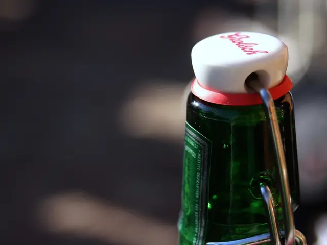 In the picture we can see a green color bottle with a sticker on it and we can also see a cap which...