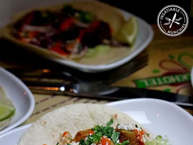 In this image we can see food items in plates on the table. There is a knife. To the top right...