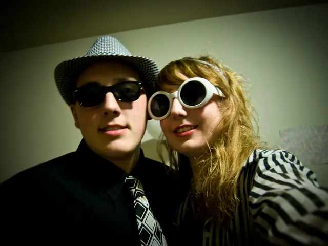 Here I can see a woman and a man smiling and giving pose for the picture. In the background, I can...