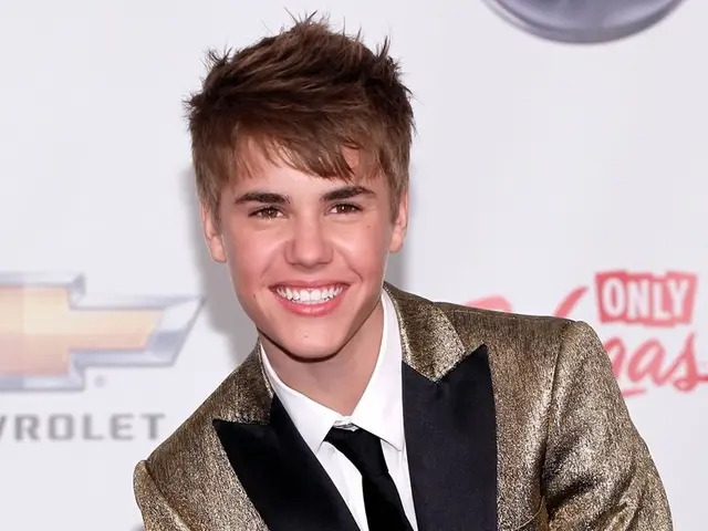 In this image in the foreground there is one man who is smiling and in the background there is a...