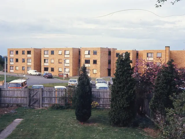 In the image I can see a place where we have some buildings, trees, plants, cars and some other...