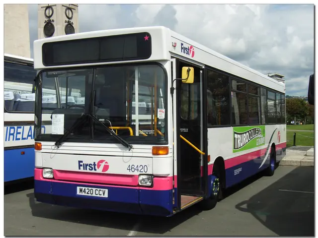 At the bottom of the image there is a road with buses. Behind the bus there is a footpath. Behind...