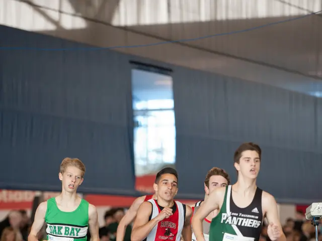 In the picture there is an indoor stadium, there are some people running, beside there are many...