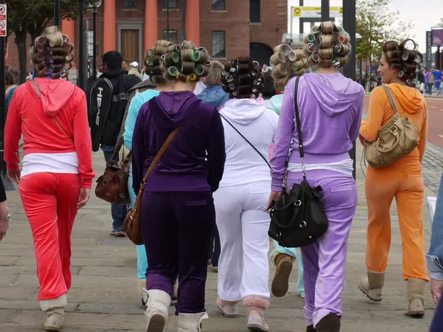 There is lot of girls walking towards the building wearing same type of costume in different colors...