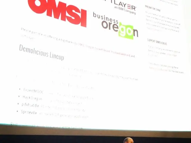 In this image I can see at the bottom a man is standing and speaking in the microphone, he wore...