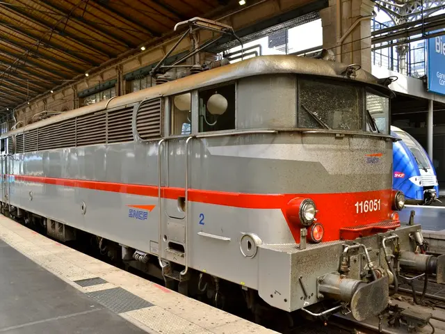 In the foreground of this image, there is an engine on the track. On the left, there is a platform....