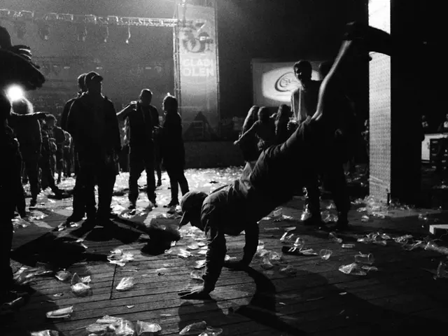 In this image in the center there is a person performing stunt. In the background there are persons...