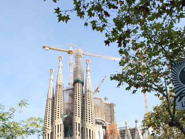 In the image,there is a big building's construction is going on and there is a huge crane and...