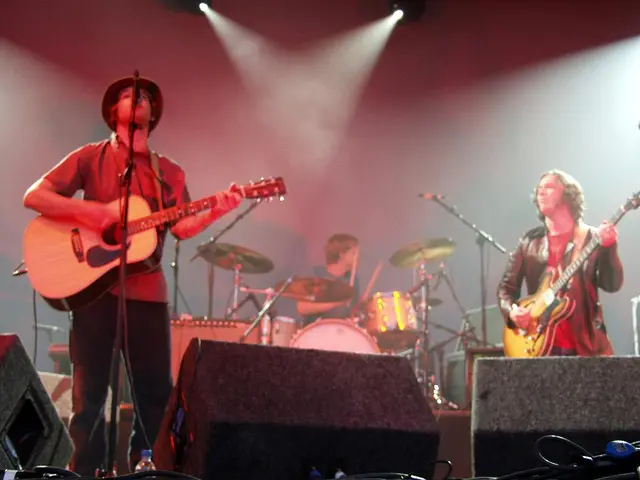 The person wearing red dress is playing guitar and singing in front of a mike and the person in the...