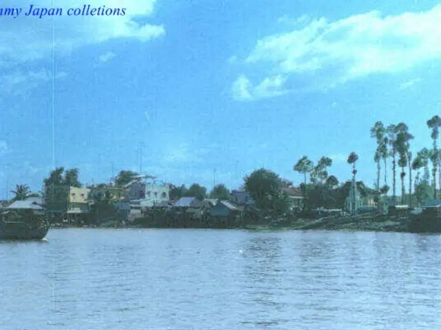 In this image there is a river in that river there is a boat, in the background there are houses...