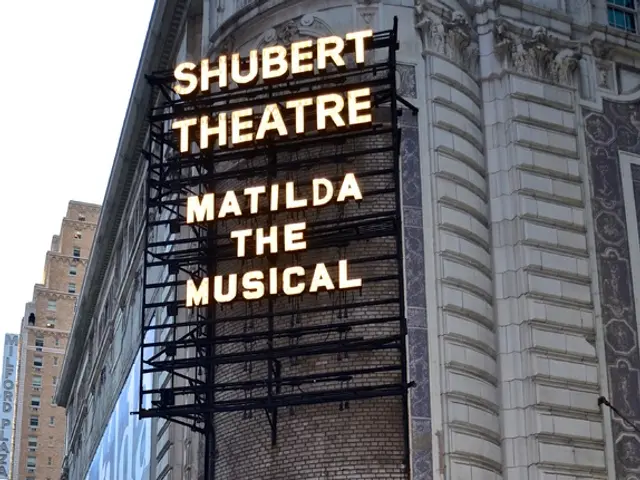 In this picture we can see group of people, buildings and hoardings, and we can find a baby in the...