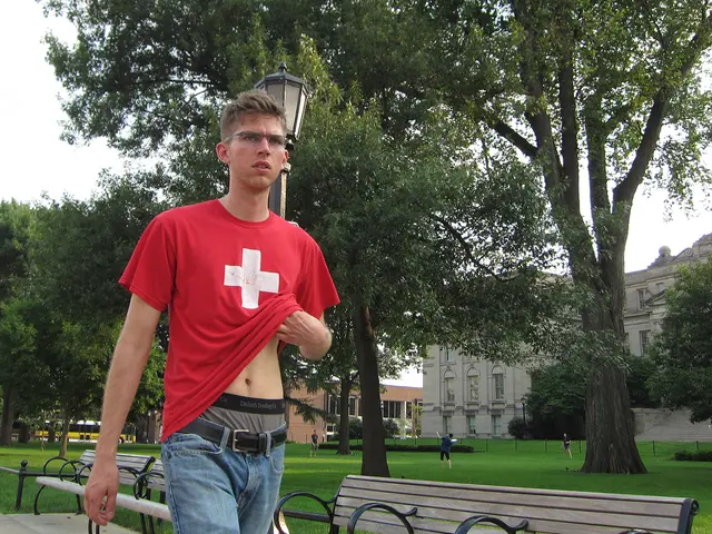 In this image there is a man who is wearing a red t-shirt, blue jeans and a underwear. Besides him...