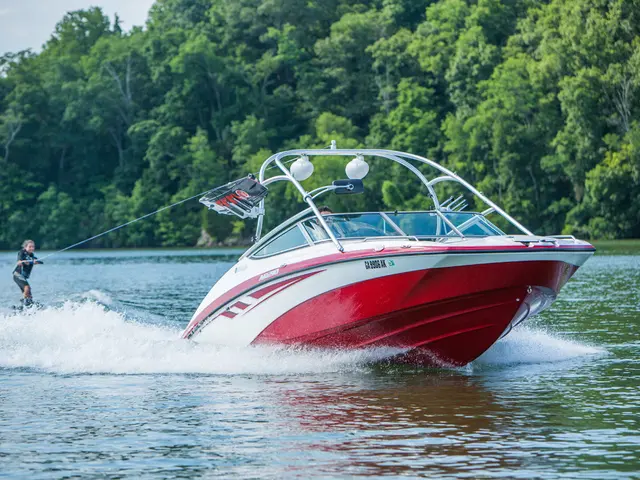 In this image there is a girl who is surfing in the water by holding the rope which is tied to the...
