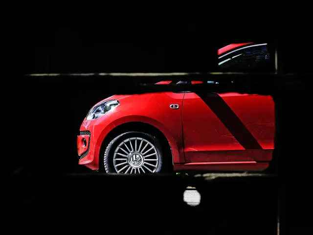 There is a red color car and the background of the car is dark.