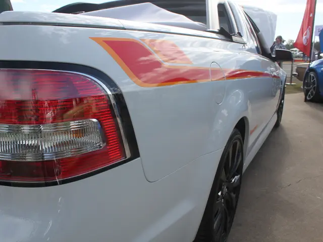 In this image, there is a car which is colored white. There is an another car in the top right of...