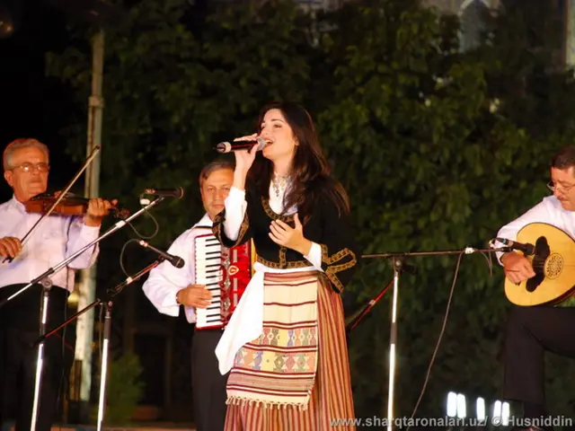 There is a woman with gown singing on mic in the front and three men playing other musical...