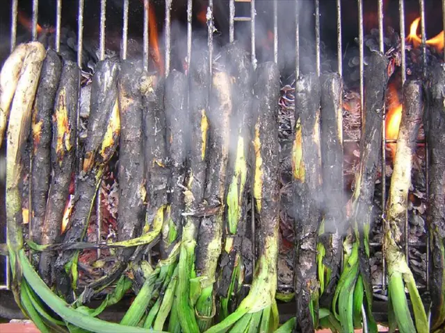 In this picture we can see leafy vegetables on the grills and we can see fire.