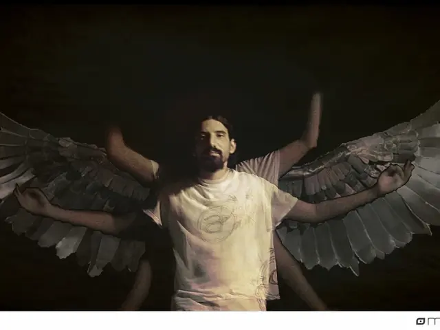 The man in the middle of the picture wearing white T-shirt is standing. Behind him, we see a man...