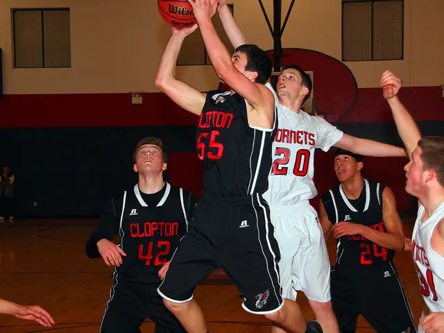 In this image there are group of boy's playing basket ball, beside them there is a wall with...