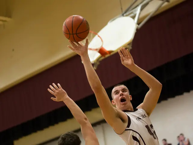 In this image I can see two men are wearing t-shirts and shorts and playing the volleyball. The man...