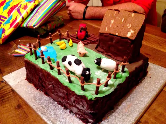 This image contains a table having few gift packs and a cake and few candles are on it. On cake...