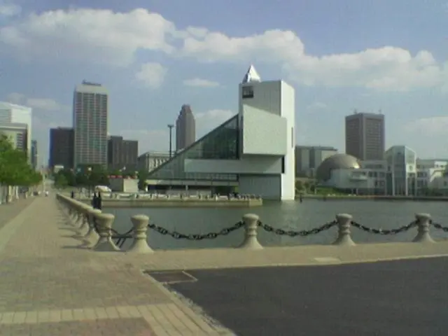 In the image there is a path and there is a water surface behind the fencing, in the background...