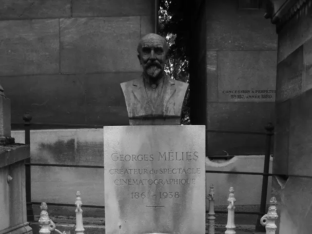 This is a black and white image. Here I can see a graveyard on which there is a sculpture of a...