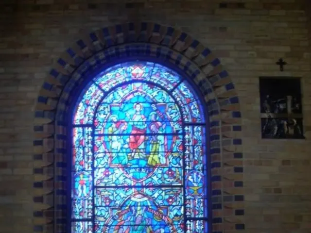 This is an inside view of a church. In the background we can see a frame and holy cross symbol on...