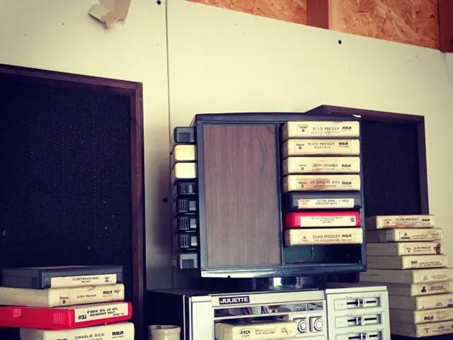 In this picture, we see a table on which television, DVDs and a white color object are placed. We...